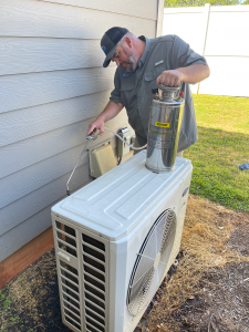 A technician from Dolan Design servicing a mini split condenser.